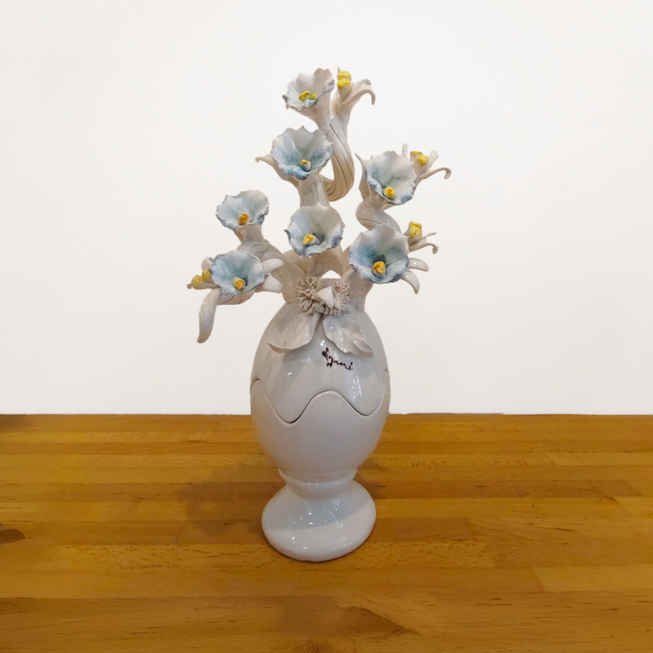 Uovo di Pasqua in ceramica finitura lucida con base e fiori scultorei