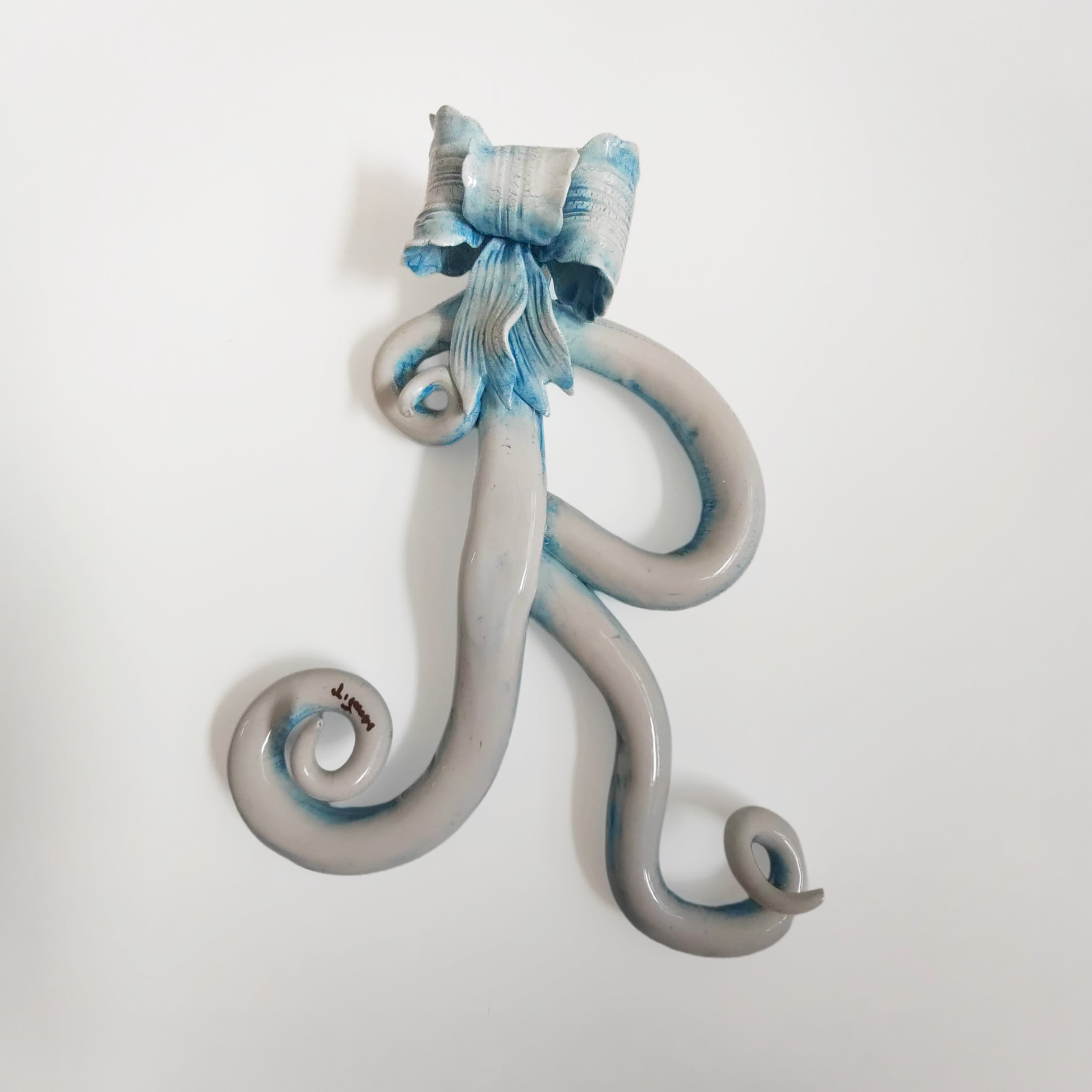 Iniziale decorativa in ceramica con fiocco