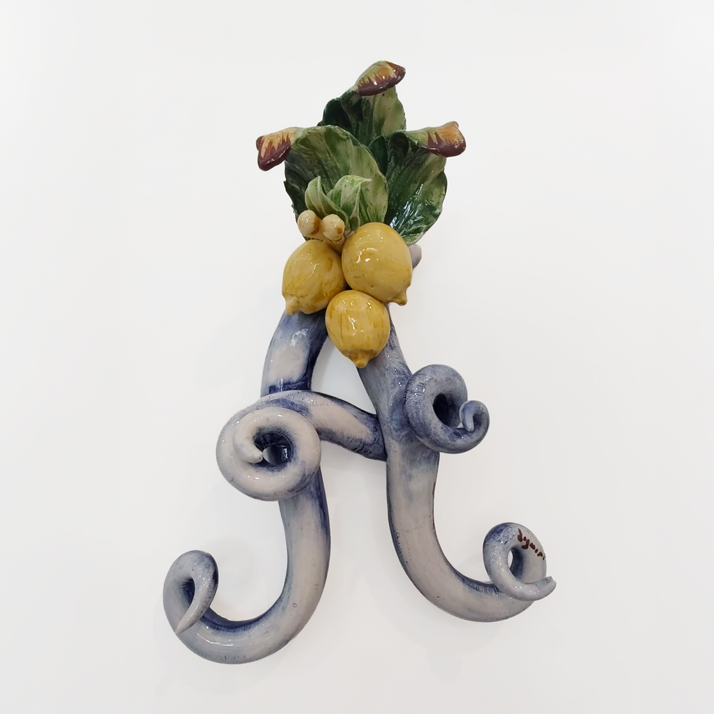 Iniziale decorativa in ceramica con limoni