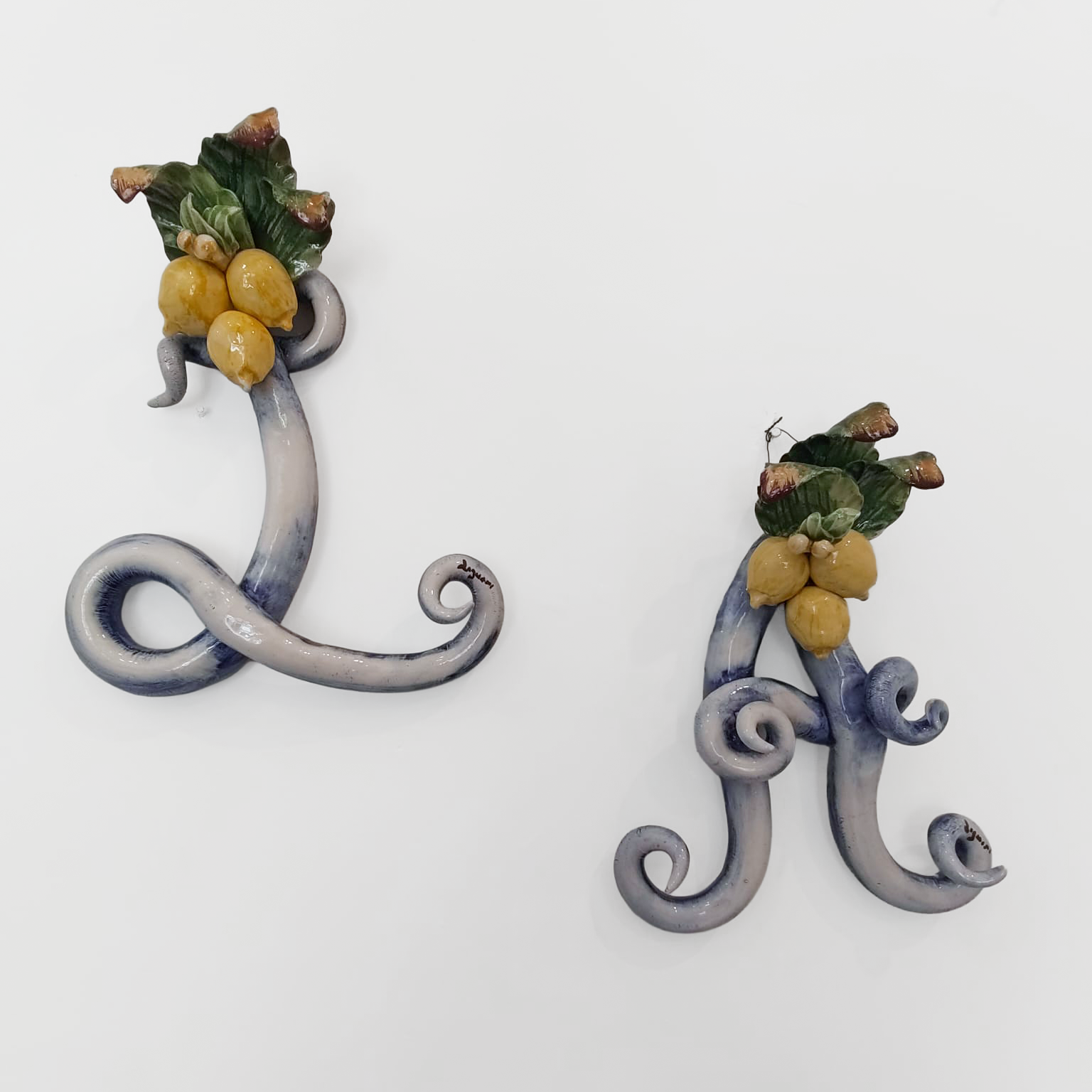 Iniziale decorativa in ceramica con limoni