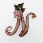 Iniziale decorativa in ceramica con fiori