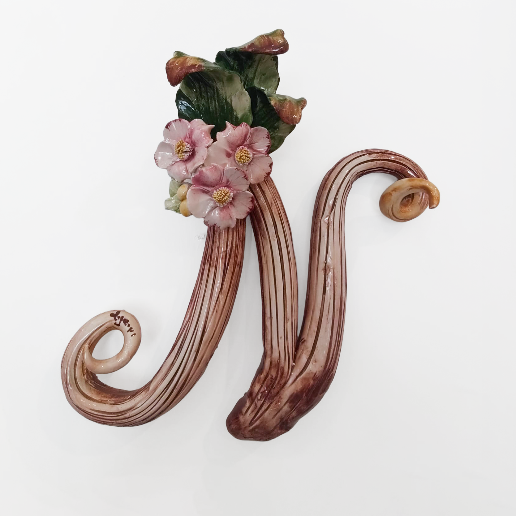 Iniziale decorativa in ceramica con fiori