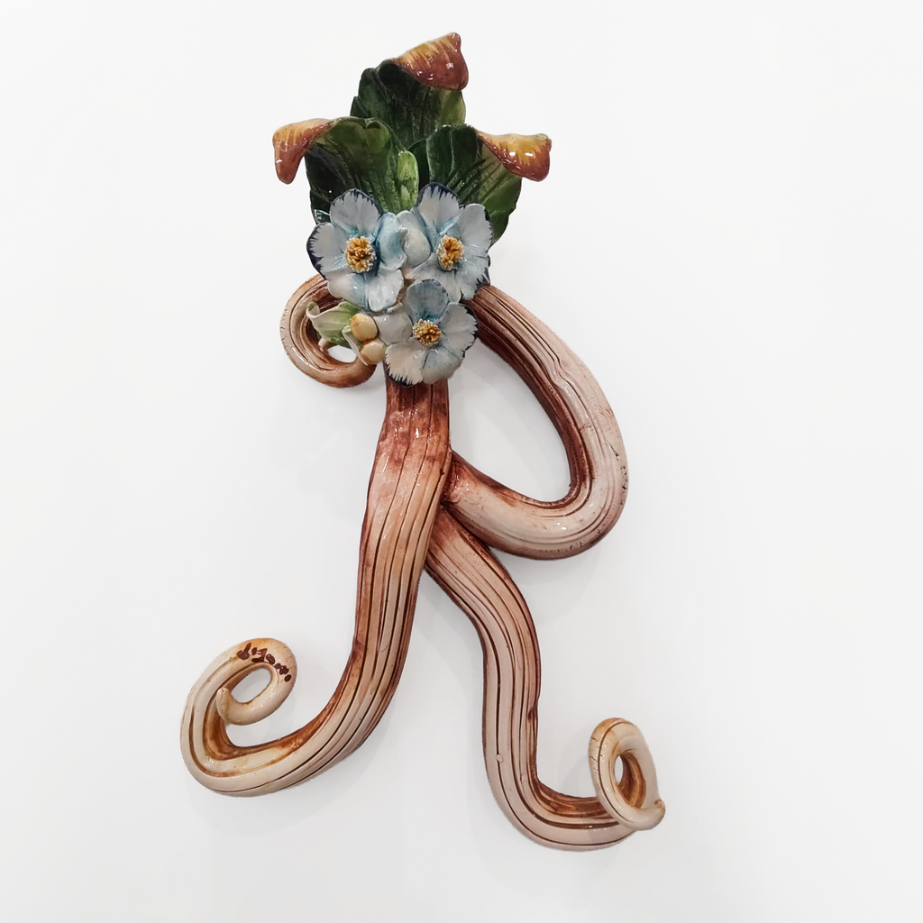 Iniziale decorativa in ceramica con fiori