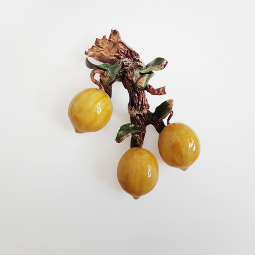 Applique in ceramica con frutta su tronco