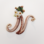 Iniziale decorativa in ceramica con fiori
