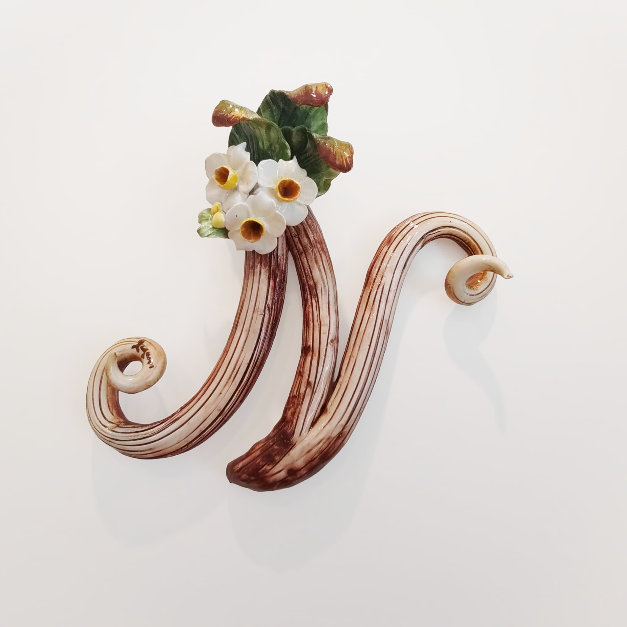 Iniziale decorativa in ceramica con fiori