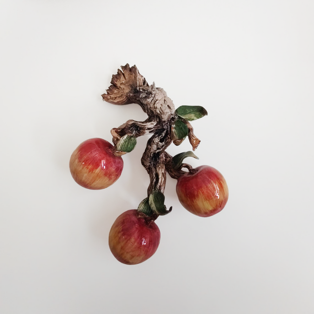 Applique in ceramica con frutta su tronco